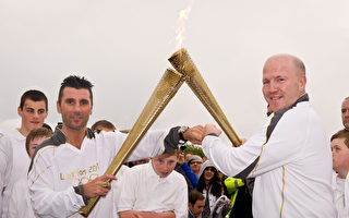 倫敦奧運火炬傳遞進入第19天。拳擊運動員Wayne McCullough（左）和Michael Carruth在北愛爾蘭和愛爾蘭的邊界進行奧運火種交接（Dan Kitwood/Getty Images）