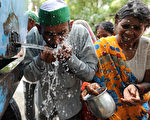 印度德里今年5、6月夏季期间，8成天数的每日最高气温破40度，平均气温达摄氏41.57度，创1980年以来最高温纪录。图为5月10日，一名农民喝水解渴。（SAJJAD HUSSAIN / AFP）