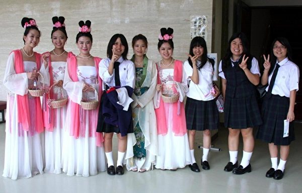 学生们非常喜欢仙女赠送的小莲花书签并纷纷要求合影。(摄影:李贤珍/大纪元) 学生们非常喜欢仙女赠送的小莲花书签并纷纷要求合影。(摄影:李贤珍/大纪元)