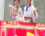 《东门四少》男女主角张雁名、房思瑜特别搭升高机登高10米揭开“东门四少、传家之宝”巨幅字轴为戏造势祈福。(摄影:黄宗茂/大纪元)