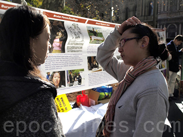 7月20日，在悉尼市政厅广场，悉尼法轮功学员为纪念“7•20”法轮功反迫害13周年打出各种横幅，图为澳洲人来了解真相。（摄影：伊罗逊/大纪元）    