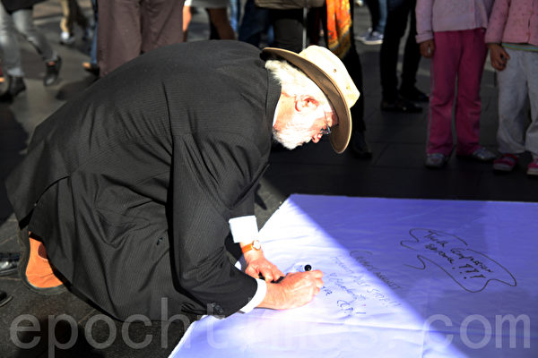 7月20日，在悉尼市政厅广场，悉尼法轮功学员为纪念“7•20”法轮功反迫害13周年举办集会活动。图为澳洲民众签名声援法轮功，要求停止迫害。（摄影：袁丽/大纪元）
