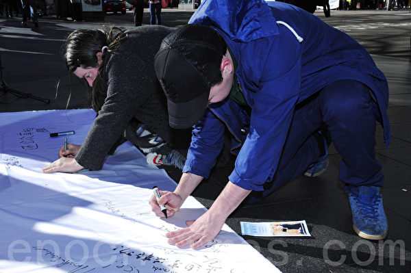 7月20日，在悉尼市政厅广场，悉尼法轮功学员为纪念“7•20”法轮功反迫害13周年举办集会活动。图为澳洲民众签名声援法轮功，要求停止迫害。（摄影：简玬/大纪元）