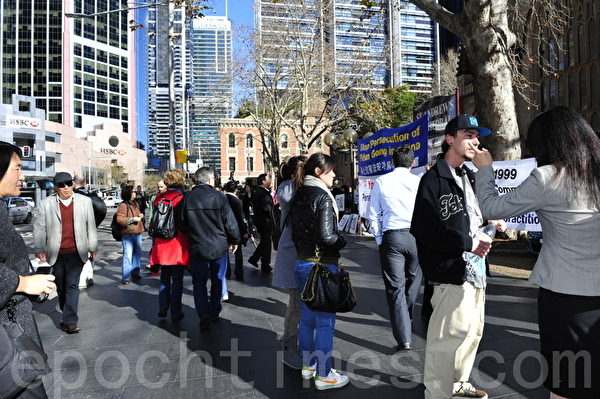 7月20日，在悉尼市政厅广场，悉尼法轮功学员为纪念“7•20”法轮功反迫害13周年打出各种横幅，图为澳洲民众来了解真相。（摄影：简玬/大纪元） 