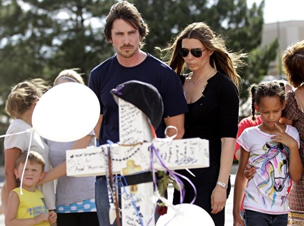 克里斯蒂安•贝尔（Christian Bale）和妻子一起献花悼念枪击案的死难者。(Joshua Lott/Getty Images)