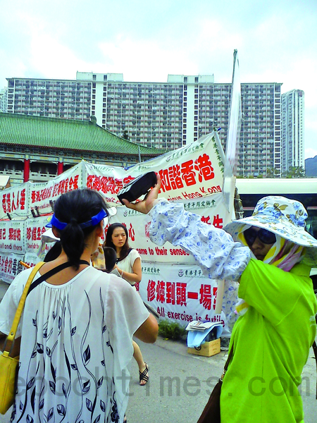 在黃大仙真相點,親共惡徒用高音量喇叭貼身轟襲法輪功學員,但警方卻不制止。(大紀元) 在黃大仙真相點,親共惡徒用高音量喇叭貼身轟襲法輪功學員,但警方卻不制止。(大紀元)