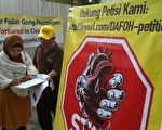 法轮功学员在印尼雅加达中使馆前征集签名，呼吁民众协助制止中共活摘暴行。这些签名会通过DAFOH直接递交给联合国。图中标志，为网络阻中共活摘器官标志。（明慧图片）