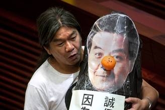 香港立法會議員梁國雄抗議梁振英知法犯法僭建,一再說謊操守差,應該下台。圖為今年7月16日,梁國雄就曾在立法會舉起自製道具,抗議梁振英在僭建事件上說謊,要求他下台。(PHILIPPE LOPEZ/AFP/GettyImages) 香港立法會議員梁國雄抗議梁振英知法犯法僭建,一再說謊操守差,應該下台。圖為今年7月16日,梁國雄就曾在立法會舉起自製道具,抗議梁振英在僭建事件上說謊,要求他下台。(PHILIPPE LOPEZ/AFP/GettyImages)