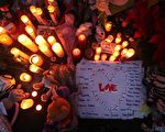 康涅狄格州桑迪胡克小學26名師生遭到血腥槍擊殺害後，受害者家屬、校方和各界在2012年12月17日為罹難者舉行追悼會，現場佈滿追悼燭光與送給死亡學生的玩具布偶。(Mario Tama/Getty Images)
