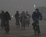 中國大陸空氣污染影響擴大，包括日企在內約上百家公司已收到中國政府要求暫停作業的指示。圖為2013年1月29日，北京，空氣污染嚴重，騎車民眾紛紛戴上口罩。(Feng Li/Getty Images)
