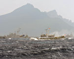 中日兩大亞洲強權近日的釣魚島爭端，加劇了雙邊的緊張局勢。本圖後方的小礁島即為釣魚島，左邊的船艦是日本海上保安廳的巡邏艦。（攝影YEH/AFP/GettyImages）