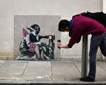 英國塗鴉教父班克西（Banksy）作品本月稍早從倫敦的1面牆上消失，之後卻出現在美國的拍賣會上，拍賣商已經取消拍賣。圖為2012年5月17日，倫敦，班克西失竊的塗鴉畫。（Peter Macdiarmid/Getty Images）