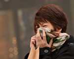 北京屡屡爆表的空气污染水平令人担忧，很多外籍驻华人士出于对健康风险的考虑选择离开中国，一些中国企业高管也开始寻求搬到更干净的城市。图为北京一名中国女人。(Mark RALSTON/AFP)