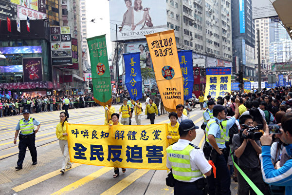 香港法輪功學員4月28日舉行反迫害集會遊行,紀念425和平大上訪14周年,遊行隊伍途徑港島的鬧市區,氣勢磅礡的陣勢吸引大批中港民眾觀看。(攝影:潘在殊/大紀元)
香港法輪功學員4月28日舉行反迫害集會遊行,紀念425和平大上訪14周年,遊行隊伍途徑港島的鬧市區,氣勢磅礡的陣勢吸引大批中港民眾觀看。(攝影:潘在殊/大紀元)