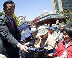 5月29日，舊金山市議長邱信福在向老人派發防拍拍行購物袋。（攝影：周鳳臨／大紀元）