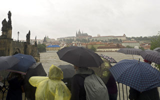中歐近日持續豪雨，捷克宣布進入緊急狀態。圖為3日在夫塔瓦河畔目睹暴雨中的布拉格的遊客。(MICHAL CIZEK/AFP/Getty Images)