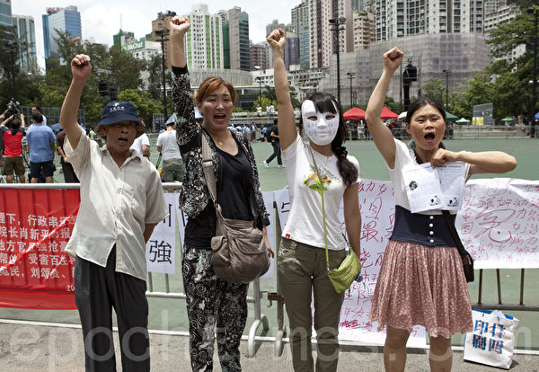 四名大陆访民参加七一大游行,在维园高呼口号:打倒贪官,打到腐败。访民左起:访民刘颂贵、访民王艳、一名抗议强拆的深圳访民和访民冉崇碧。(摄影:余钢/大纪元)