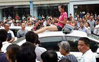 城管打傷司機 妻子持刀爬警車抗議 千人聲援（組圖）