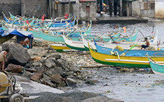 2013年8月12日，台风尤特挟带强暴风雨肆虐菲律宾，造成今天23人失踪。图为吕宋岛北部海岸渔船。（JAY DIRECTO / AFP）