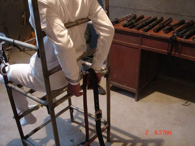 酷刑:雙手反背銬在椅子上(明慧網)