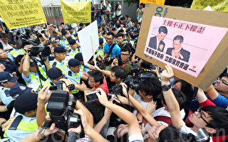 香港行政長官梁振英星期日出席第三場論壇，建制派空前出動擁護者，用黑道和暗箱操作的手法，製造反對聲在場內消音的虛假現場效果，梁振英同時在場外出動大批有中共背景的團體霸佔主要示威區，以高聲擴音器掩蓋抗議聲。圖為香港當局出動大批警察護駕，超過四百名市民到場抗議要求梁振英下台，部分人與警方發生衝突。（潘在殊／大紀元）