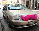 網絡共乘服務在舊金山迅猛發展，圖為帶著私家車的網絡共乘服務Lyft的標識——粉鬍子的汽車。（曹景哲/大紀元）