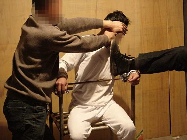 酷刑演示图:警察对被固定着的雷明拳打脚踢。 (明慧网) 酷刑演示图:警察对被固定着的雷明拳打脚踢。 (明慧网)