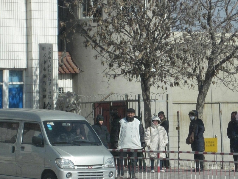 李珊珊丈夫周向阳的父亲身穿“状衣”在监狱门口要儿子。(明慧网)