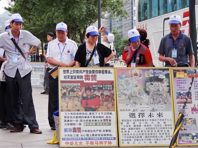 黄浦江死猪事件让许多大陆游客对中国的生态污染悲观绝望,全球许多退党服务中心,中国观光客“三退”踊跃。图为台北101大楼前,驻足观看法轮功真相展板的中国观光客。(明慧网)