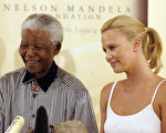 2004年3月11日，非洲第一位奧斯卡影后查理茲‧塞隆與曼德拉合影。（Naashon Zalk/Getty Images）