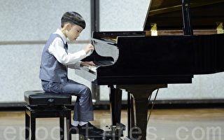 儿童B组选手林灏维演奏钢琴的专注神情。（苏玉芬／大纪元）