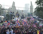 泰國軍方近日以陸軍節閱兵名義，將坦克、大砲、直升機運進首都曼谷。圖為1月5日在曼谷反政府示威遊行隊伍經過閱兵紀念碑。（PORNCHAI KITTIWONGSAKUL／AFP）
