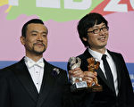 導演刁亦男（右）與男主角廖凡獲獎後開心合影。（DAVID GANNON/AFP/Getty Images）