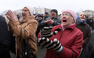 烏克蘭頓內茨4日超過1千名示威者手持「我是俄羅斯人，我不需要被保護」標語，力挺基輔當局。(ALEXANDER KHUDOTEPLY/AFP)