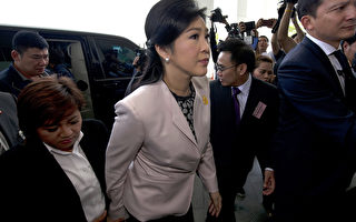 泰國總統盈拉(中)31日帶著大批文件，前往國家肅貪委員會為自己申辯。(PORNCHAI KITTIWONGSAKUL/AFP)