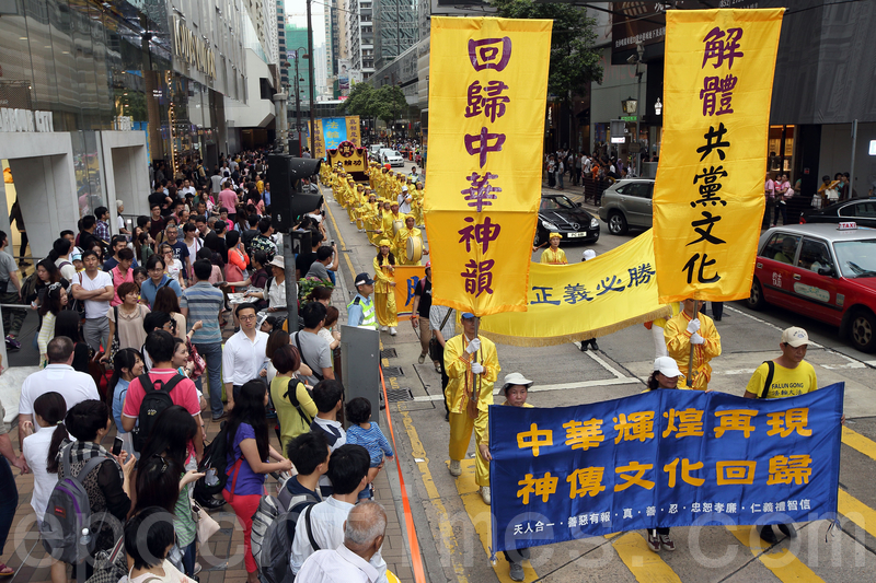 香港法轮功学员4月20日举行声势浩大的游行,纪念“四.二五”和平大上访15周年,大约八百人游行队伍沿着九龙的闹市区,途经多个大陆游客购物热点,吸引两旁的大批游客观看,许多人拿着手机和相机争相拍摄。(潘在殊/大纪元)