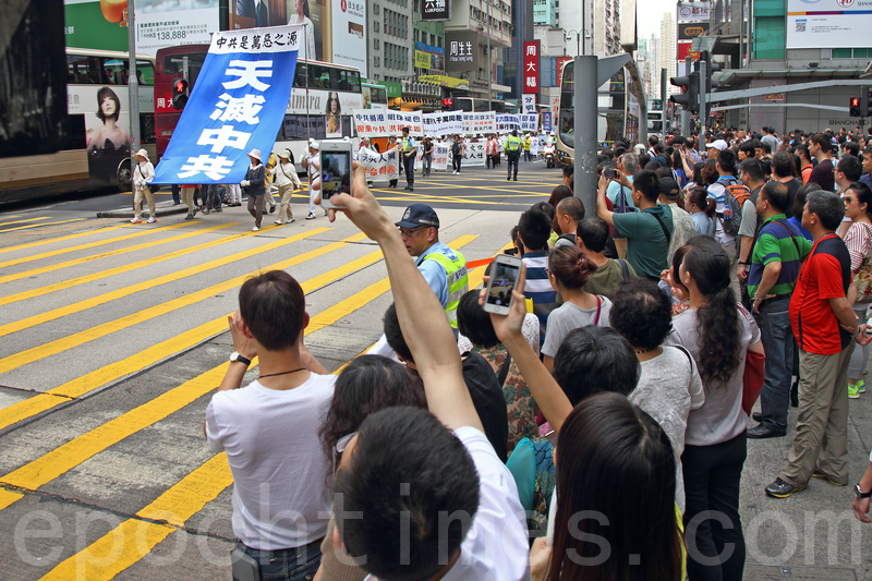 香港法轮功学员4月20日举行声势浩大的游行,纪念“四.二五”和平大上访15周年,大约八百人游行队伍沿着九龙的闹市区,途经多个大陆游客购物热点,吸引两旁的大批游客观看,许多人拿着手机和相机争相拍摄。(潘在殊/大纪元)