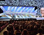 2014年5月14日晚，本屆戛納電影節主席、新西蘭導演簡•坎平（右）在開幕式上與作曲家邁克爾•尼曼、主持人朗貝爾•威爾森在台上致辭。（ALBERTO PIZZOLI/AFP/Getty Images）