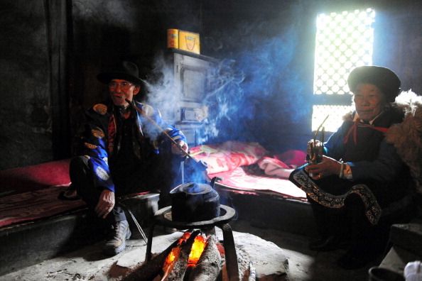 普米族處於雲南邊緣地區，婚期大多選在冬閒時節。圖為兩位普米族人坐在炕上。（圖/Getty Images）