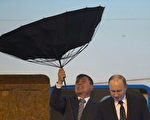 5月20日，俄羅斯總統普京在風雨中抵滬，下飛機時傘被大風吹折。普京當天還與中共前黨魁江澤民會見，當天官媒集體噤聲，微博「學習粉絲團」發消息，提普京講話，但江無話罕見成「啞巴」。（Ng Han Guan／AFP）