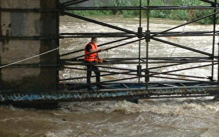 台北市消防局30日下午獲報，文山區景美橋溪水暴漲，
1名年約70歲老翁掉落溪中。圖為救護人員搶救。
（台北市消防局提供）