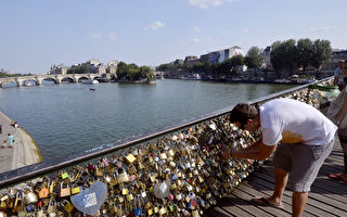 每对情侣只要来到法国塞纳河畔的巴黎艺术桥，总要挂上一个爱情锁，盼望从此紧扣不分离。(MIGUEL MEDINA/AFP)
