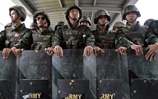 泰國軍政府於2014年6月1日宣佈，政府將討論30個緊急振興經濟方案，以防止因政局動盪而不斷下滑的經濟困境擴大。圖為軍方於1日在曼谷佈署6千軍力，企圖圍堵反政變的示威群眾。（AFP/Christophe ARCHAMBAULT）