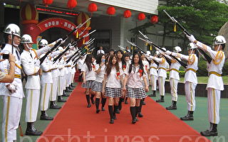 畢業同學通過該校樂儀隊的劍門走出校門。（李容耕／大紀元）