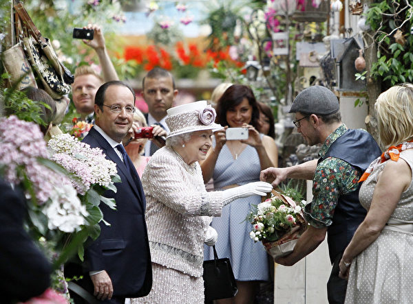 女王走訪花市時接受人們贈送給她的鮮花。(FRANCOIS MORI/AFP)
女王走訪花市時接受人們贈送給她的鮮花。(FRANCOIS MORI/AFP)