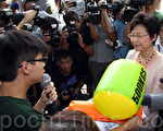 政務司司長林鄭月娥出席政改研討會時遇上學民思潮示威，拒絕接收膠錘道具和公開辯論。（潘在殊／大紀元）