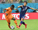 日本队首战失利，长友佑都深感自责。图为长友佑都(右)与科特迪瓦球员Serge Aurier在比赛中。(ISSOUF SANOGO/AFP)