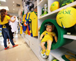 巴西官方预计，在世界杯期间的国内外游客的旅游收入为67亿巴西雷亚尔（约合29.7亿美元），里约热内卢将获得其中大部分。图为：里约热内卢一家旅游商店展示的世界杯纪念品。（Mario Tama/Getty Images）