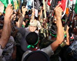 2014年6月25日，什叶派人士在什叶派城市纳贾夫挥舞著武器，表达他们志愿对抗逊尼派叛军的决心。（HAIDAR HAMDANI/AFP/Getty Images）