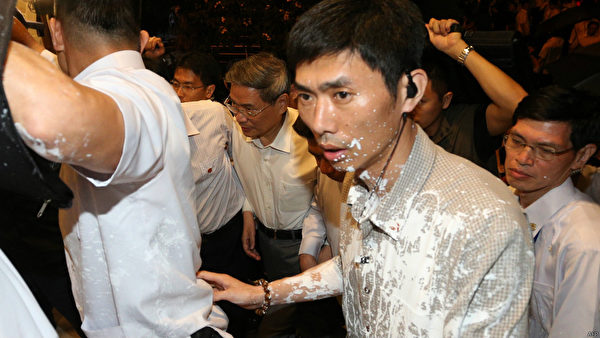 中共國台辦主任張志軍訪臺第三天晚上,遭到抗議人士潑白漆和灑冥紙抗議,他表情嚴肅心情顯然受到影響,在維安人員保護下快速進入會館。(AFP) 中共國台辦主任張志軍訪臺第三天晚上,遭到抗議人士潑白漆和灑冥紙抗議,他表情嚴肅心情顯然受到影響,在維安人員保護下快速進入會館。(AFP)